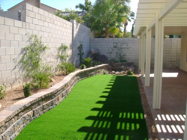 Las Vegas backyard with grass and a low brick wall