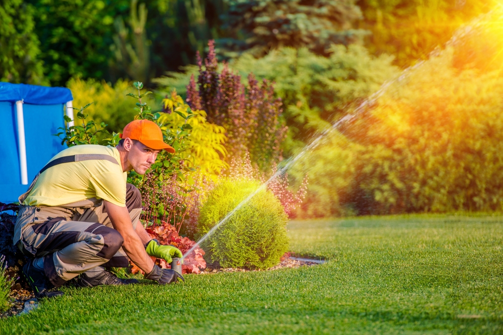 man setting up sprinkler system in need of sprinkler repair